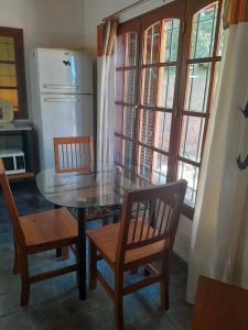 a kitchen with a table and chairs and a refrigerator at CASITA DE LAS CHACRAS SOBRE EL LAGO in San Carlos de Bariloche