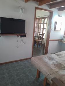 a bedroom with a bed and a flat screen tv on the wall at CASITA DE LAS CHACRAS SOBRE EL LAGO in San Carlos de Bariloche