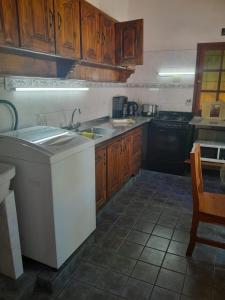 a kitchen with wooden cabinets and a sink and a stove at CASITA DE LAS CHACRAS SOBRE EL LAGO in San Carlos de Bariloche