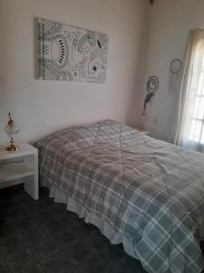 1 dormitorio con cama, mesa y ventana en CASITA DE LAS CHACRAS SOBRE EL LAGO en San Carlos de Bariloche