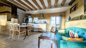 Una sala de estar con un sofá azul y una mesa. en Sainte Suzanne gite de LA CHARRETERIE, en Les Baux-de-Breteuil 16 fotos más