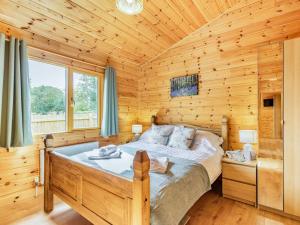 een slaapkamer met een bed in een houten hut bij 3 Bed in Lenham 86252 in Lenham