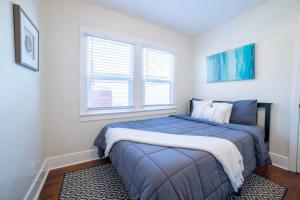 a bedroom with a blue bed and two windows at Sea View, Flower Garden, A/c, W/d, Renovated in Hermosa Beach