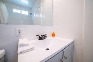 a white bathroom with a sink and a mirror at Sea View, Flower Garden, A/c, W/d, Renovated in Hermosa Beach