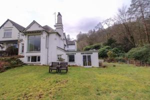 a white house with a bench in the yard at Grasmere View, stunning views over Grasmere Lake, ideal romantic break in Grasmere