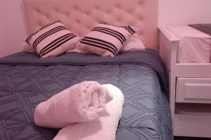 Una cama rosa con un animal de peluche. en alojamiento cataleia dep 1 Ezeiza confort hotelero a 12 minutos de Aeropuerto Ministro Pistarini en Ezeiza