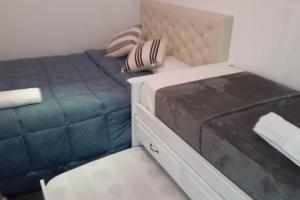 Dormitorio pequeño con cama y vestidor en alojamiento cataleia dep 1 Ezeiza confort hotelero a 12 minutos de Aeropuerto Ministro Pistarini en Ezeiza
