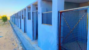 a blue building with a fence on the side of it at Corso Hub in Obour