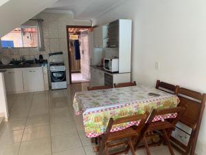 une cuisine avec une table et une cuisine avec une table et des chaises dans l'établissement Condominio Jardim Tropical, à Porto Seguro