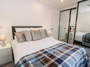 a bedroom with a large white bed with pillows at The Cottage at Cromlech Manor Farm in Benllech