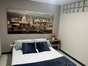 a bedroom with a bed with a painting on the wall at Hermoso Apartamento Ibague 102 Fontana 2 in Ibagué