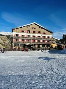 a large building in the middle of a snow covered field at Chalet Sainte Anne in Condamine-Châtelard