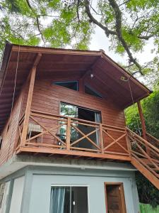 una casa con balcón en la parte superior en Casa tranquila 500 metros da praia do campeche, en Florianópolis