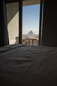 a bedroom with a bed and a view of the desert at WOW Pyramids Inn in Cairo