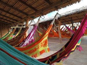 a group of hammocks hanging from a roof at EL KACHI Hospedaje y Restaurante in Uribia