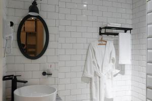 a white bathroom with a sink and a mirror at Hotel Ticiani 13 in Kutaisi