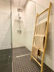 uma casa de banho com um chuveiro e uma toalha numa cadeira em datKrughuus em Emden