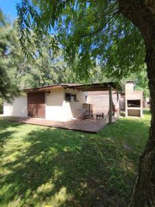 una casa con terraza de madera en un patio en Las Casuarinas, en Piriápolis