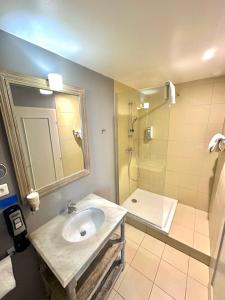 La salle de bains est pourvue d'un lavabo et d'une douche. dans l'établissement Best Western Hôtel De La Bourse, à Mulhouse