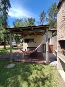 a porch with a hammock and a building at Las Casuarinas in Piriápolis