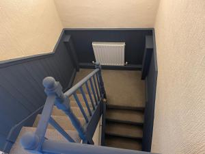 a stairway with a blue railing and a radiator at Contractor & Family House - Central Grantham in Grantham