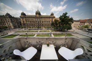 uma mesa e cadeiras em frente a um grande edifício em Roller Aparthotel em Cracóvia