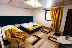1 dormitorio con 2 camas, silla y mesa en Casa Danielle en Topliţa