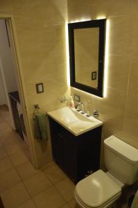 a bathroom with a sink and a toilet and a mirror at Espacio Aristobulo in Comodoro Rivadavia