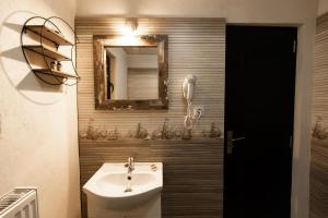 a bathroom with a sink and a mirror at Casa Danielle in Topliţa