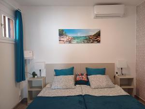sypialnia z łóżkiem z niebieską pościelą i poduszkami w obiekcie Happy Heart Los Molinos w Costa Teguise
