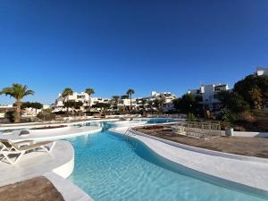 a swimming pool with blue water in a resort at Happy Heart Los Molinos in Costa Teguise