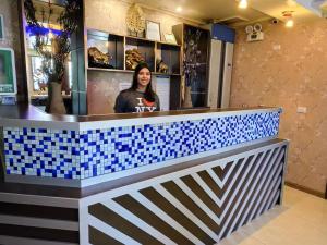 a woman standing behind a blue and white counter at Hotel Vista Mar in Puerto Montt