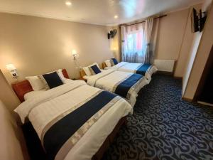 a hotel room with three beds and a window at Hotel Vista Mar in Puerto Montt
