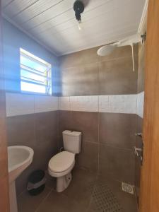 łazienka z toaletą i umywalką w obiekcie Recanto das Pedras- Casa Pedra Ardósia - Com vista para o mar w mieście Jaguaruna