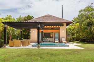 a villa with a pool and a pavilion at Newly added Tropical Bungalow at Green Village in Punta Cana