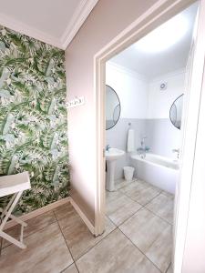 a bathroom with a tub and a toilet and a sink at Lamer Holiday Apartment 66 in Kingsburgh