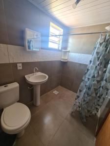 La salle de bains est pourvue de toilettes et d'un lavabo. dans l'établissement Recanto das Pedras- Casa Pedra Ardósia - Com vista para o mar, à Jaguaruna