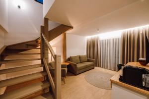 ein Wohnzimmer mit einer Treppe und einer Couch in der Unterkunft Pensiunea Sylvania in Sovata