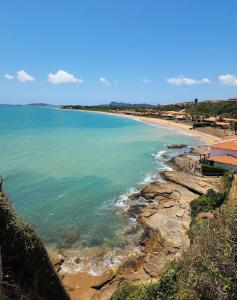 uma vista para uma praia com o oceano em Suites Vila Verde em Búzios RJ. em Búzios