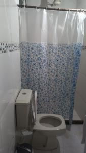 uma casa de banho com um WC e uma cortina de chuveiro em Suites Vila Verde em Búzios RJ. em Búzios
