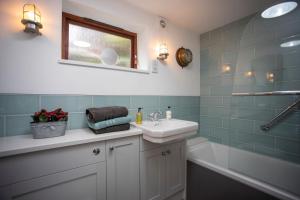 a bathroom with a sink and a bath tub at Uwch-Y-Mor in Llanfairfechan