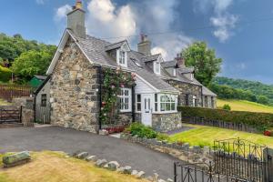 an old stone house with a christmas wreath on it at Uwch-Y-Mor in Llanfairfechan