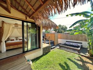 a bedroom with a bed and a patio with grass at LES VAVANGUES - L'HERMITAGE LES BAINS in La Saline les Bains