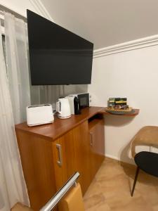 Habitación con barra con microondas y TV. en Termálfürdő Apartman Igal 2 perc a fürdőtől en Igal