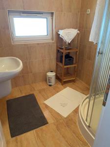 a bathroom with a sink and a toilet and a window at Termálfürdő Apartman Igal 2 perc a fürdőtől in Igal