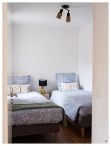 1 dormitorio con 2 camas y lámpara en Magnifique F3 Classé 3 Étoiles à 20 min de Paris & Disney, en Villiers-sur-Marne