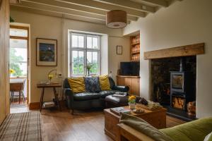 uma sala de estar com um sofá e uma lareira em Uwch-Y-Mor em Llanfairfechan