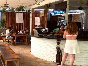 una mujer parada frente a un bar en Maracuyá Hostal Zipolite - Coworking Space, en Zipolite