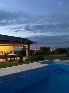 a swimming pool in front of a house with a picnic table at Casa de Descanso. in Villa María