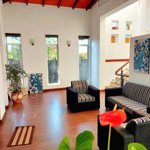 a living room with two couches and a staircase at Home immersed in nature in Kottawa